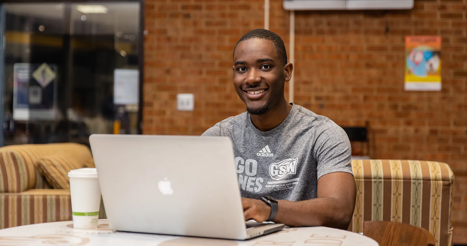 Student working on laptop at coffee shop