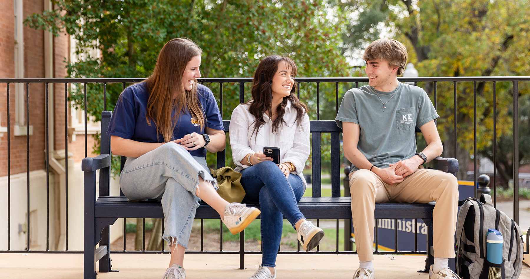 Students sitting on bench laughing