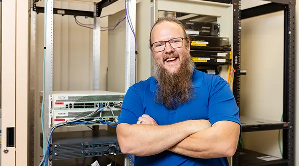 Adult student in front of servers in data center