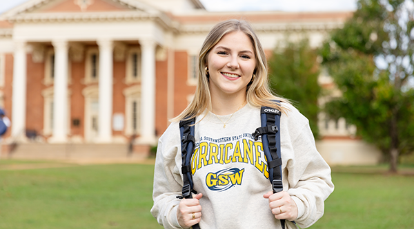 Female student standing on front lawn