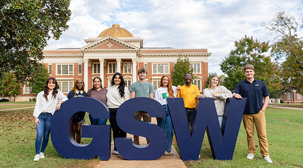 Group of students in front of Admin building with GSW letters