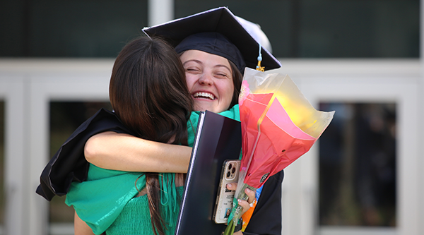 Graduate hugging her friend
