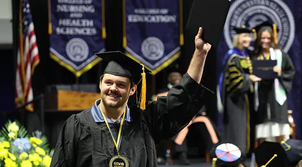 Graduate looking into crowd after receiving diploma