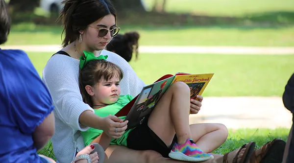Woman reading with PreK Student