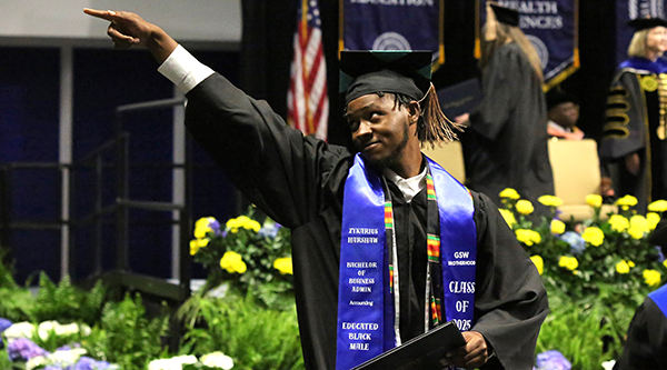 Graduate pointing into the crowd