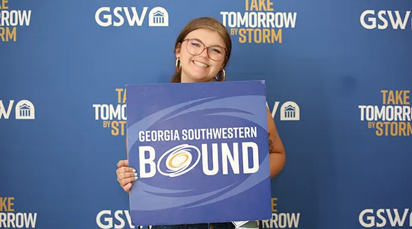 Student attending Storm Day holding a prop card