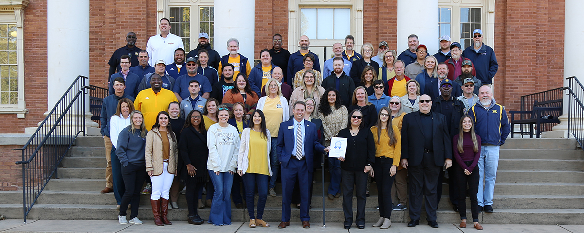 faculty and staff pose with Best Place to Work award