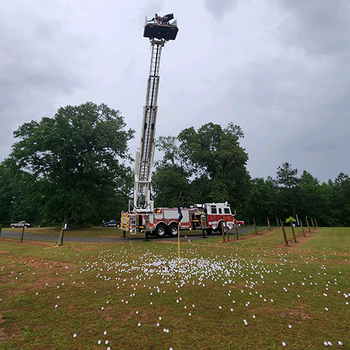 golf balls are dropped from a raised fire truck ladder