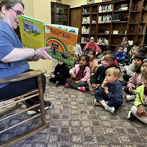 Pre-K students listen to story in library