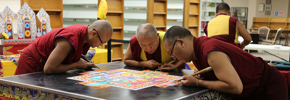 monks work on sand mandala