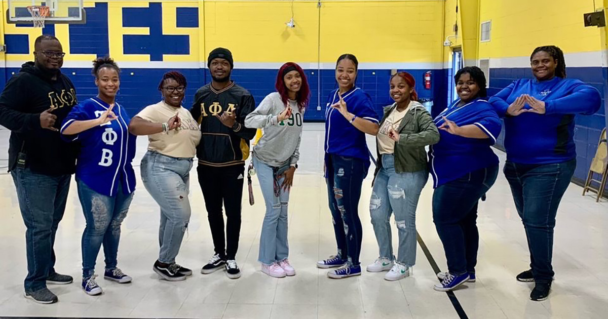 NPHC members show their letters in the elementary school gym