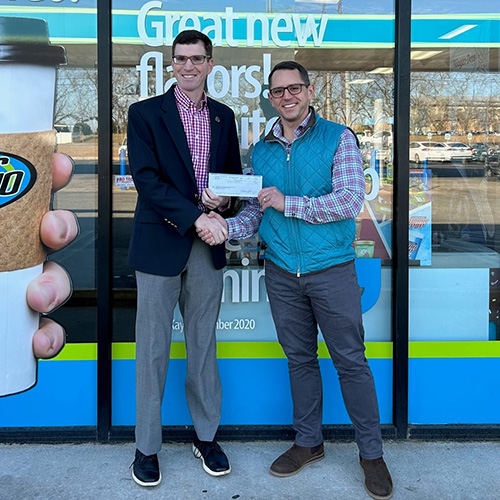 Logan Collins presents Stephen Snyder with a check in front of Gas N' Go
