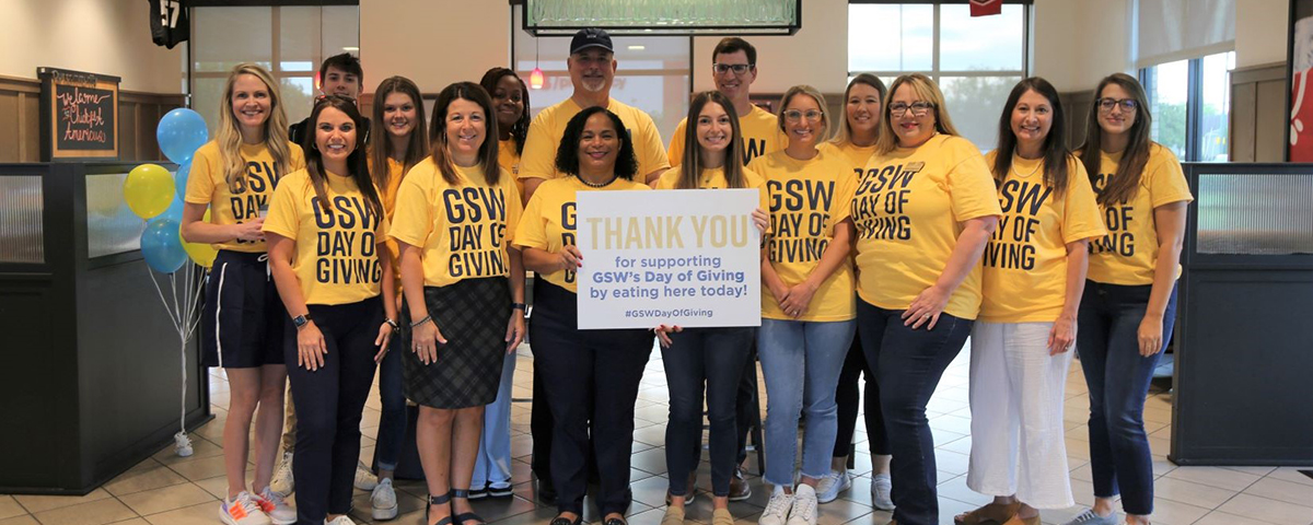 GSW staff and students pose in their gold Day of Giving shirts