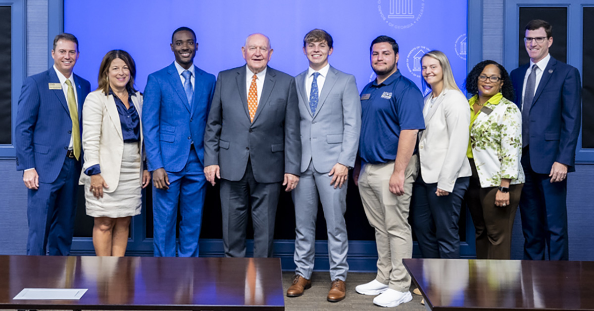 group poses with Chancellor Sonny Purdue