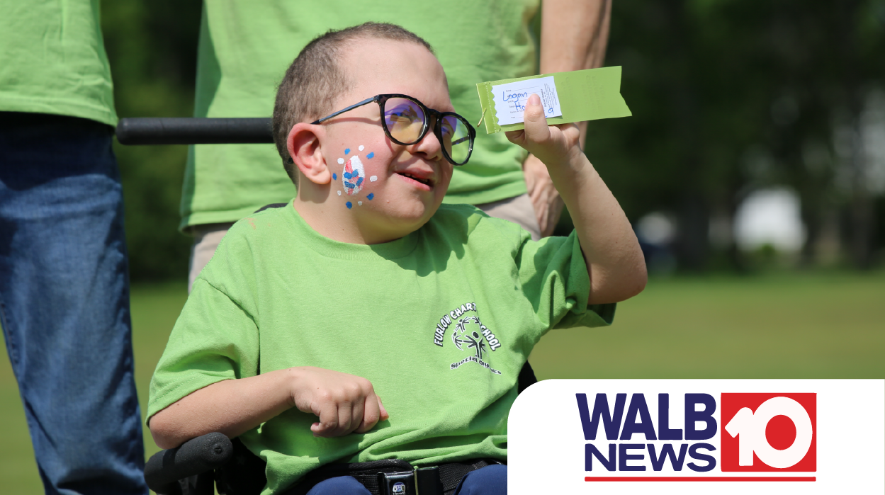 Special Olympics athlete in wheelchair shows off ribbon