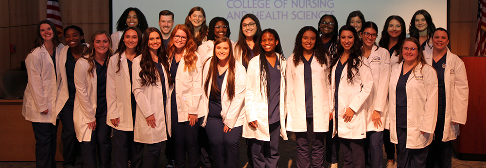 nursing class poses in white coats