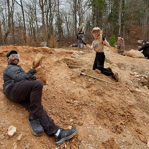 students dig for minerals in dirt bank