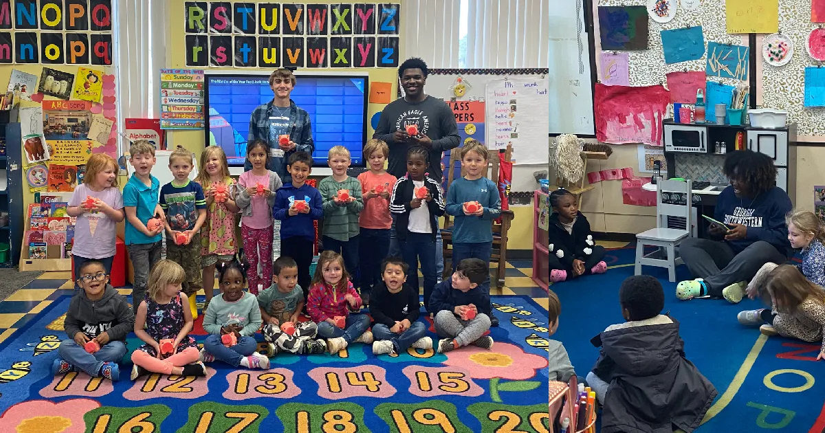 students pose with piggy banks