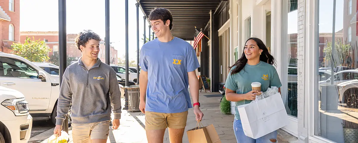 three students shopping downtown