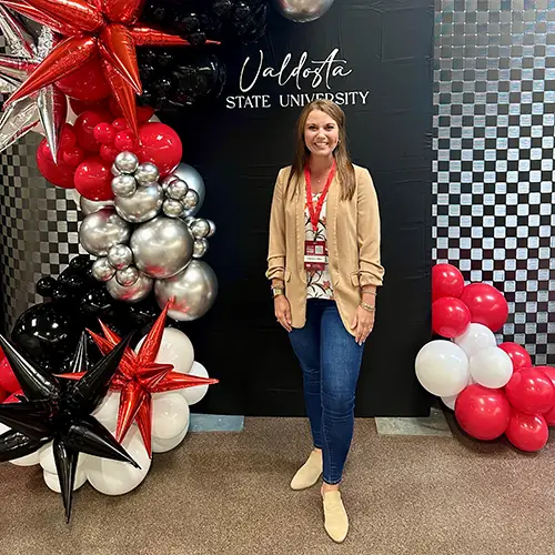 Chelsea Collins in front of black and red backdrop