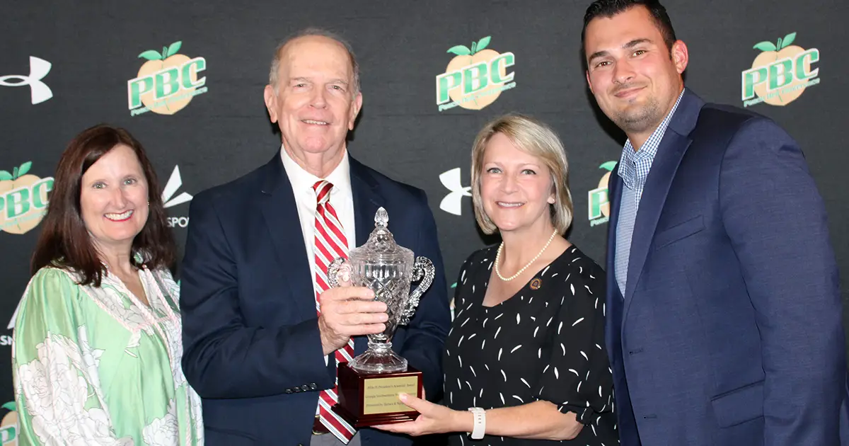 four people with trophy