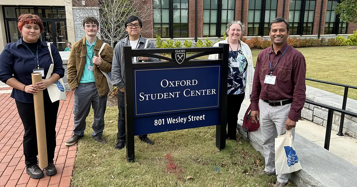 students and faculty in front of Emory University sign