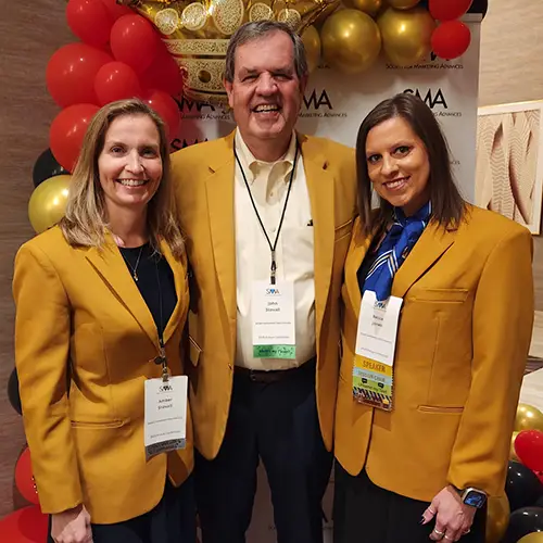 three faculty members in gold blazers