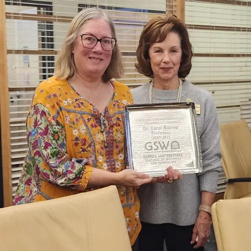 Gaynor Cheokas presents Carol Bishop with a plaque