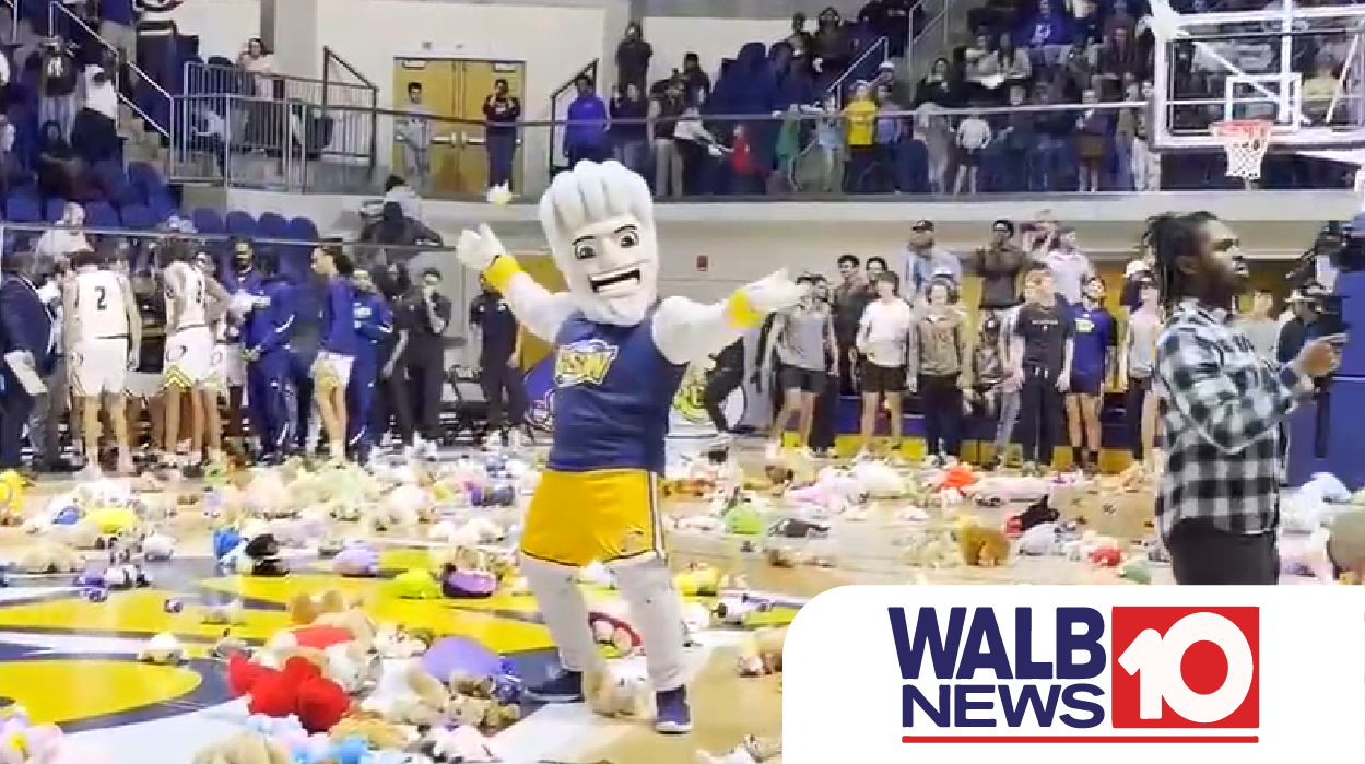 Surge dances on basketball court, surrounded by teddy bears