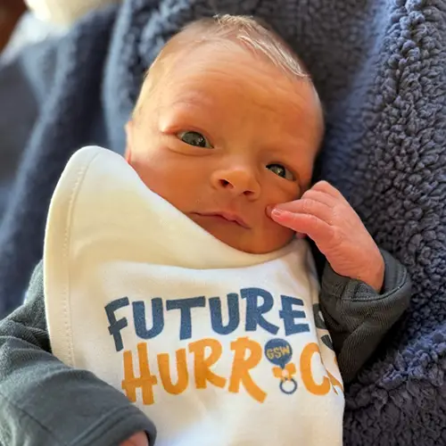 baby Riley wearing a "Future Hurricane" bib