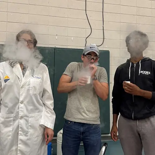 three people exhale a cloud