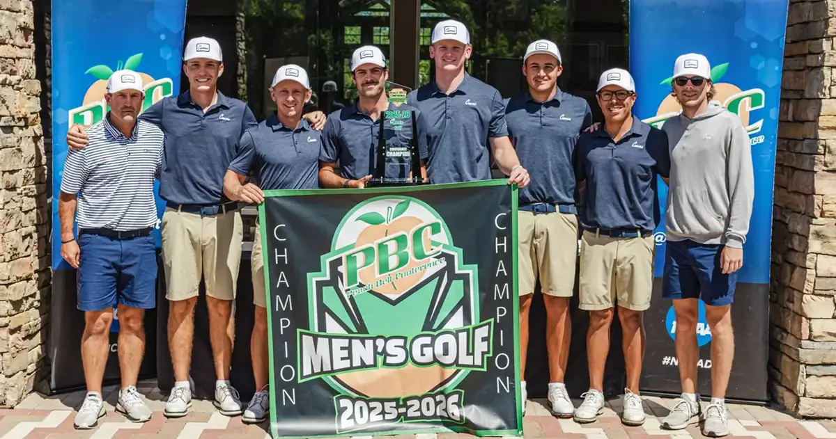 golf team holds championship banner