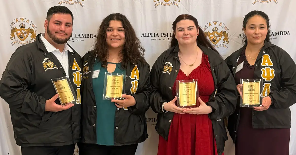 four people hold awards
