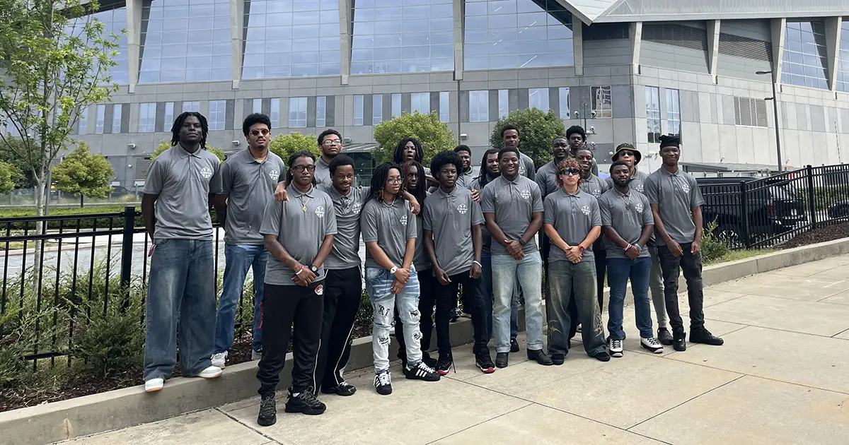 group of students pose in front of stadium