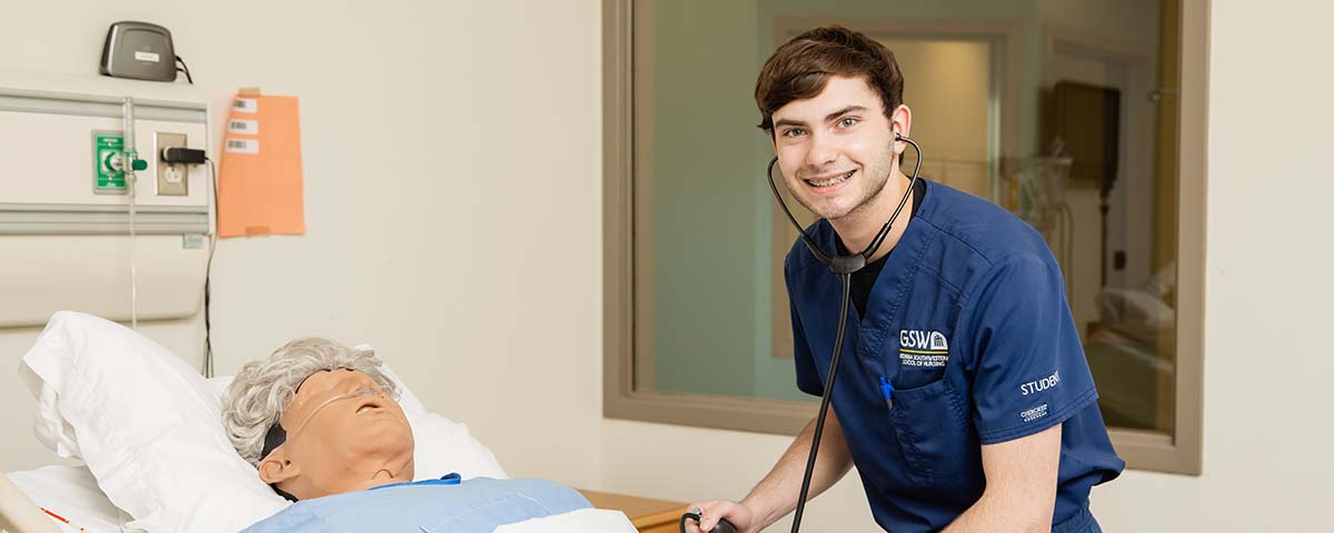 nursing student working with simulation dummy