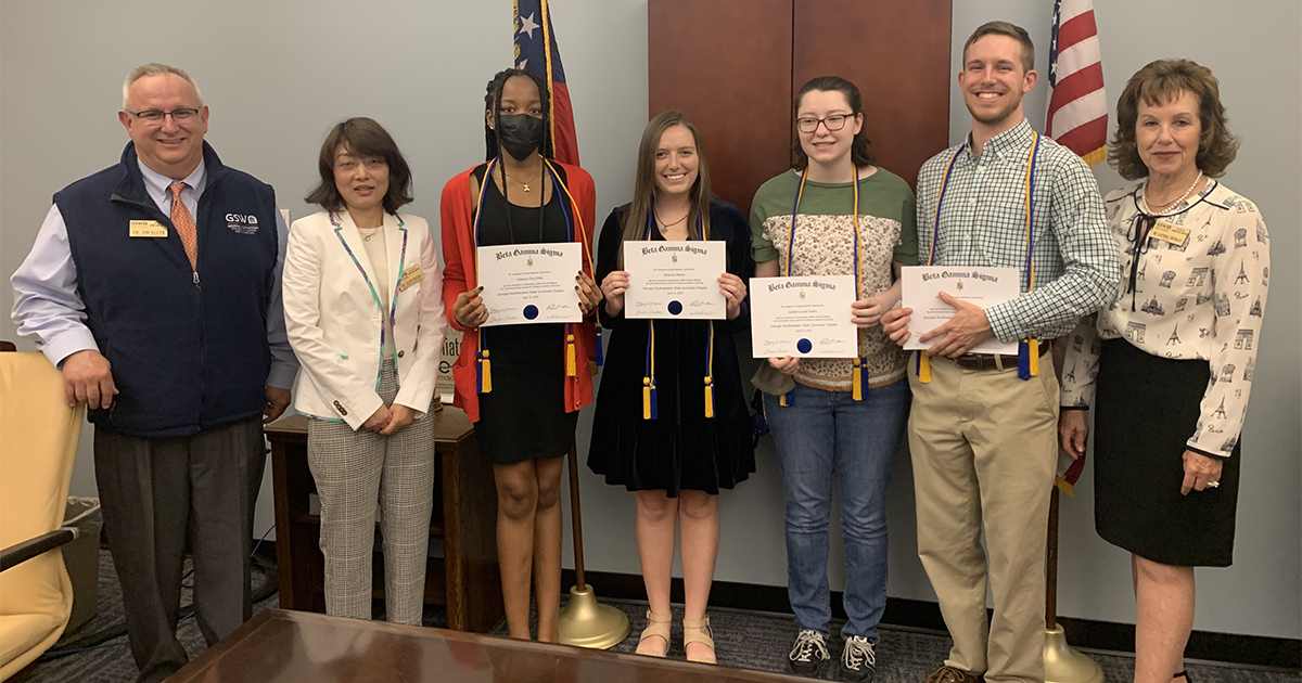 students hold certificates alongside professors