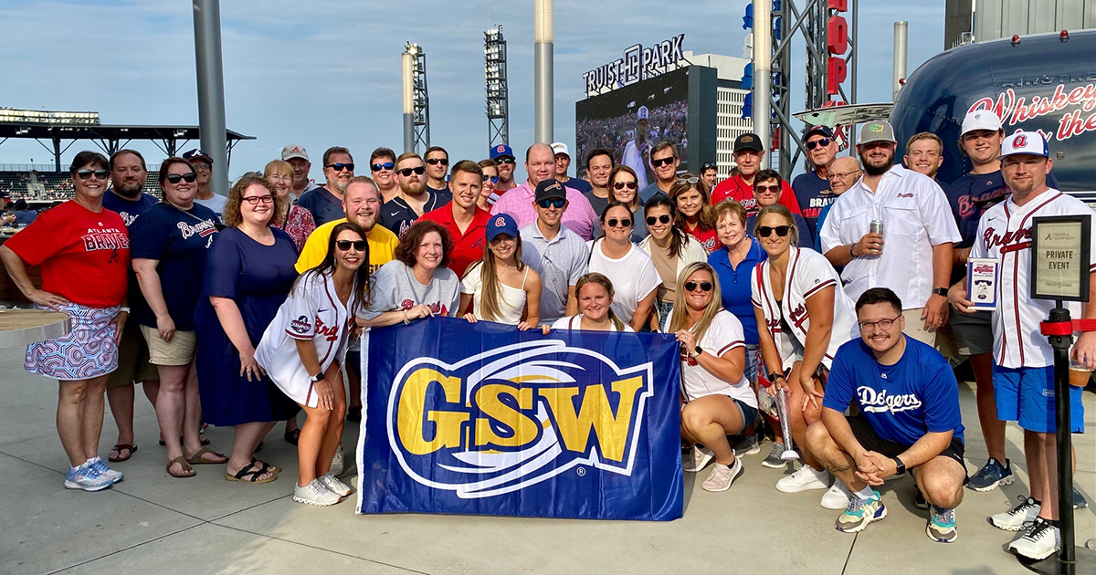alumni group holds GSW flag at baseball stadium