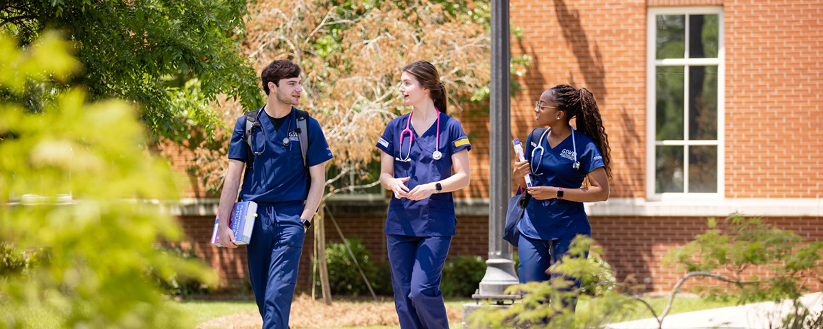 nursing students in scrubs walking outside