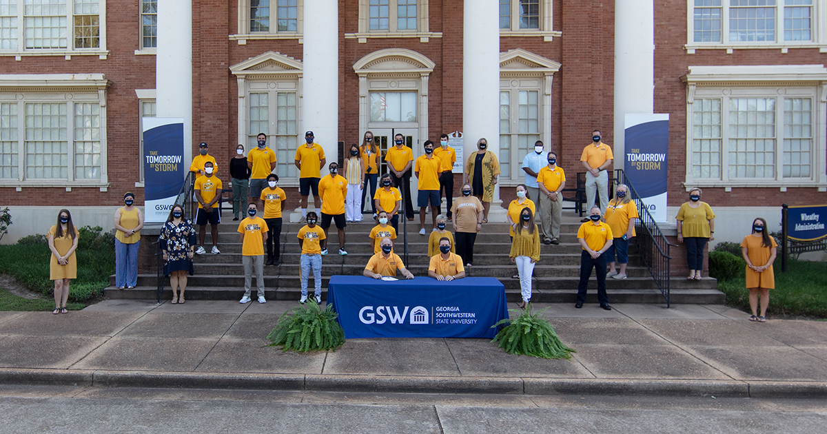 mayor signs proclamation surrounded by GSW supporters wearing gold