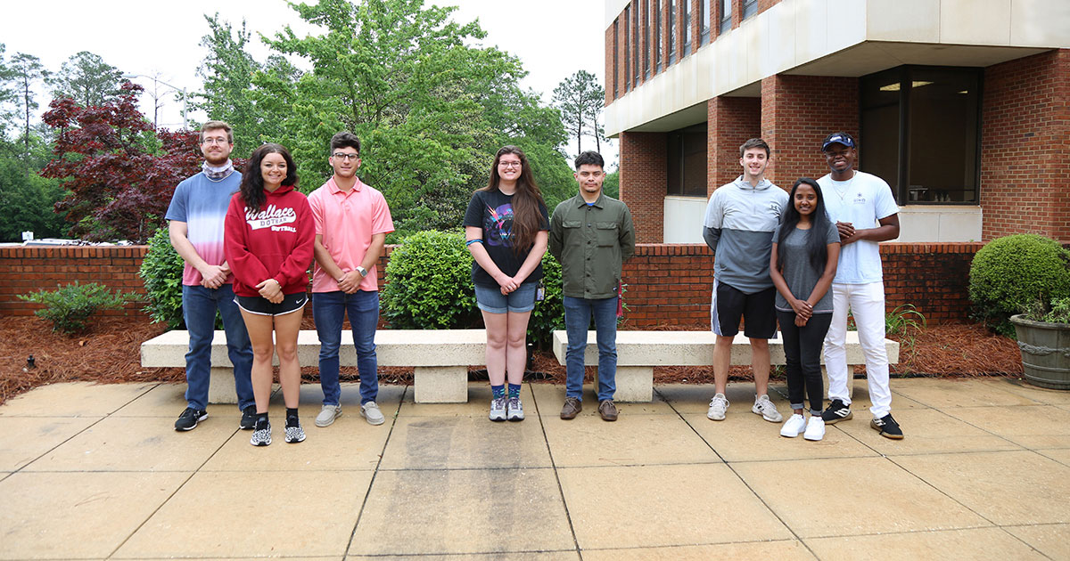 student teams stand outside