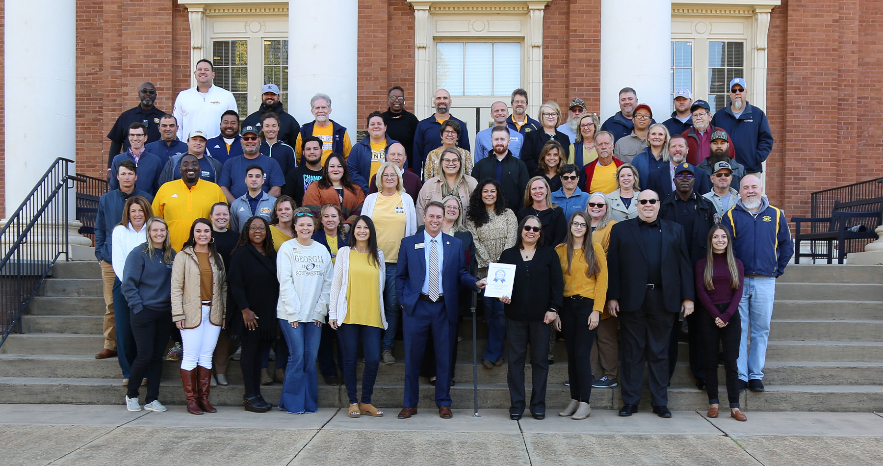 faculty and staff pose with Best Place to Work award