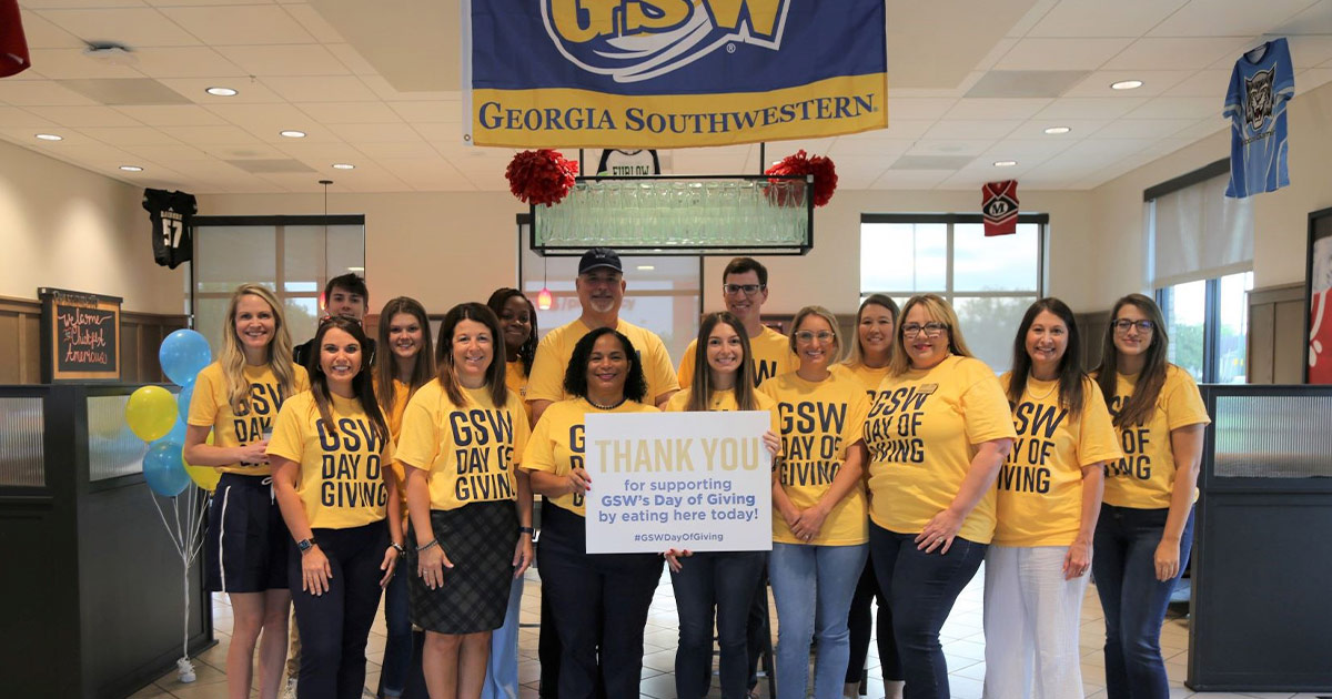 Advancement staff poses with administration at local participating restaurant