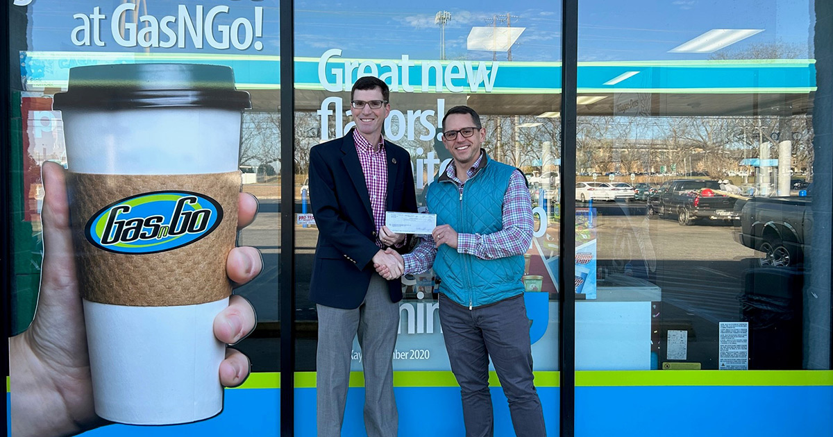 Stephen Snyder, executive director of the GSW Foundation, accepts check from Logan Collins (’13), director of accounting operations at Perry Brothers.