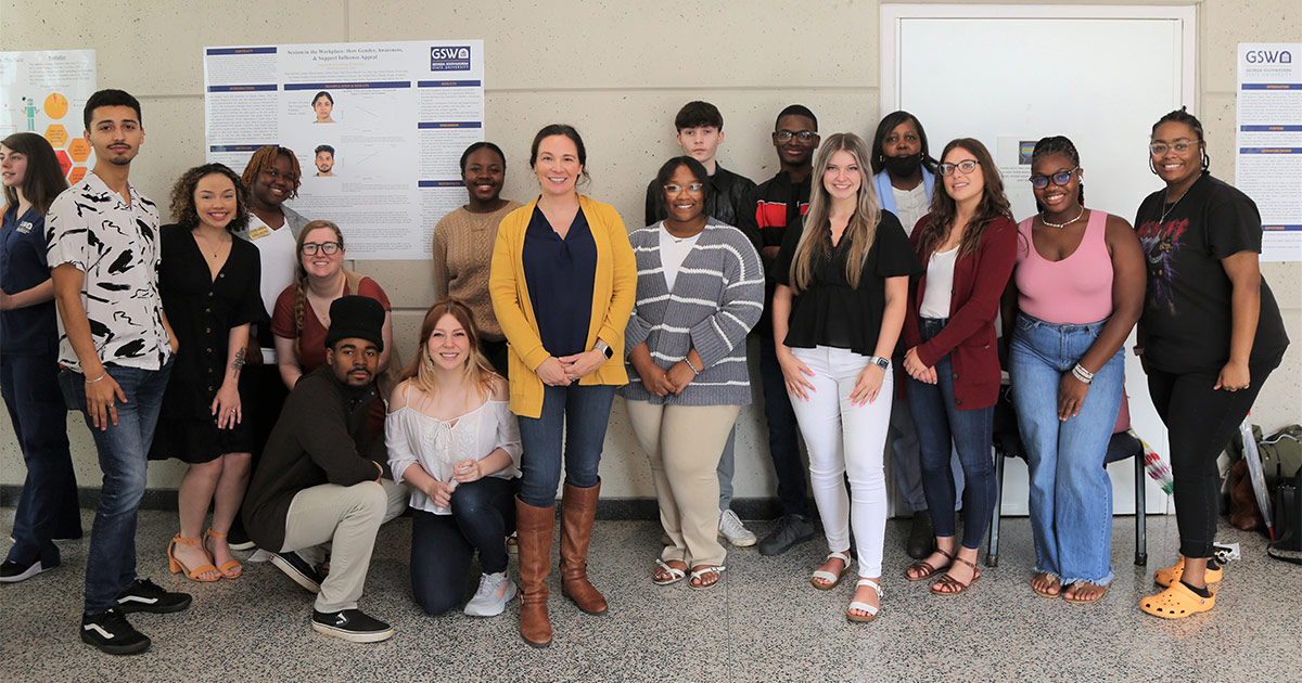 Students pose with Dr. Merritt and their poster.