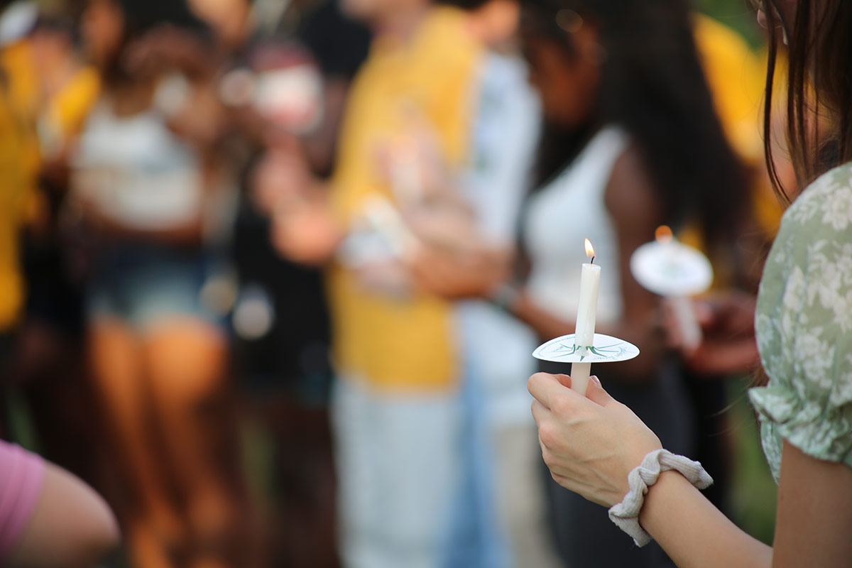 Students hold candles at vigil.