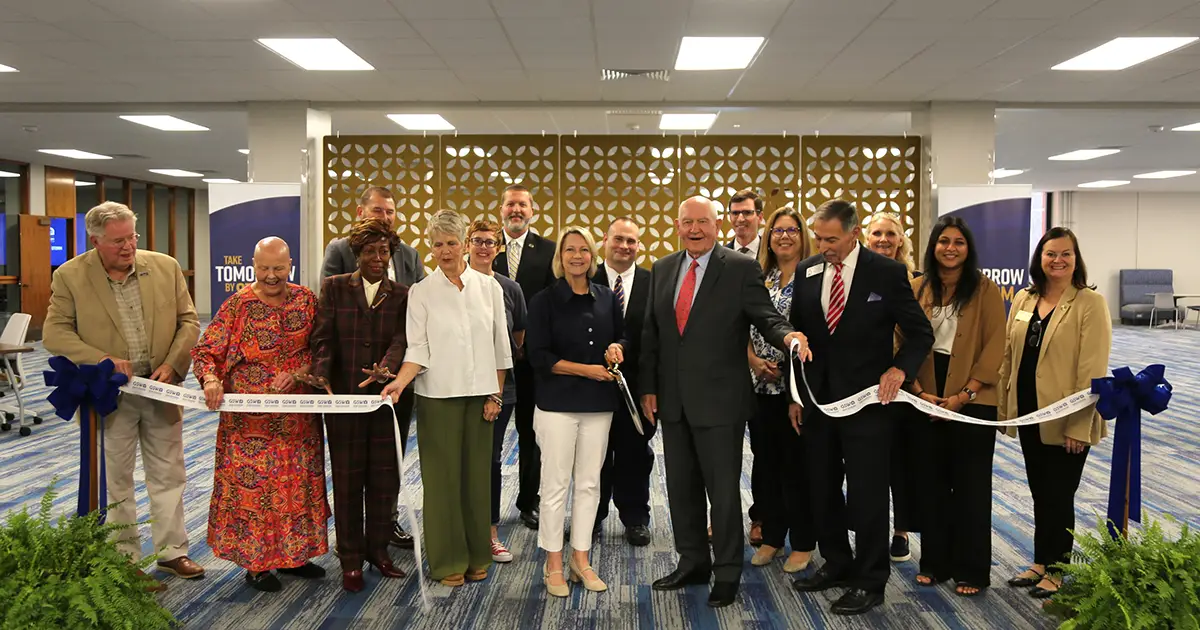 image of a group of people cutting a ribbon with oversized scissors