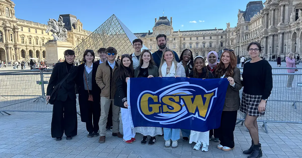 Students on study abroad trip holding GSW flag